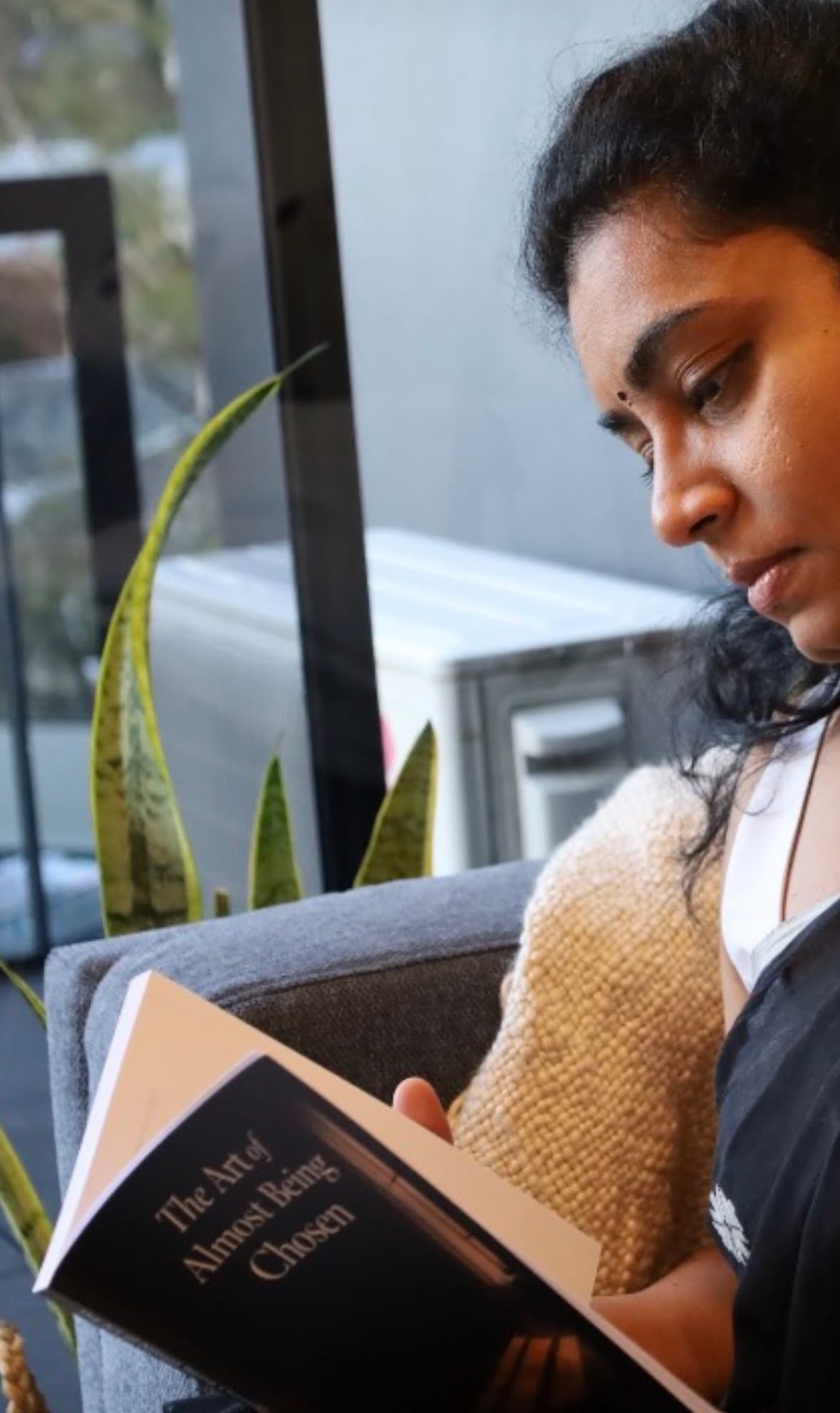 Reader absorbed in the book by a window