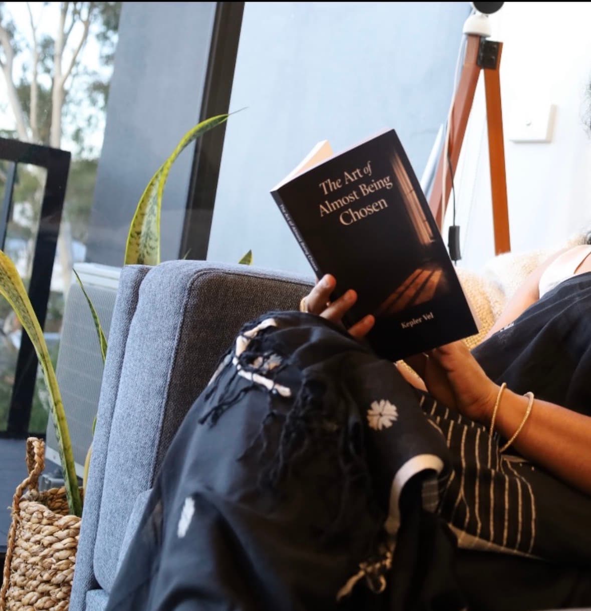 Person holding the book on a couch